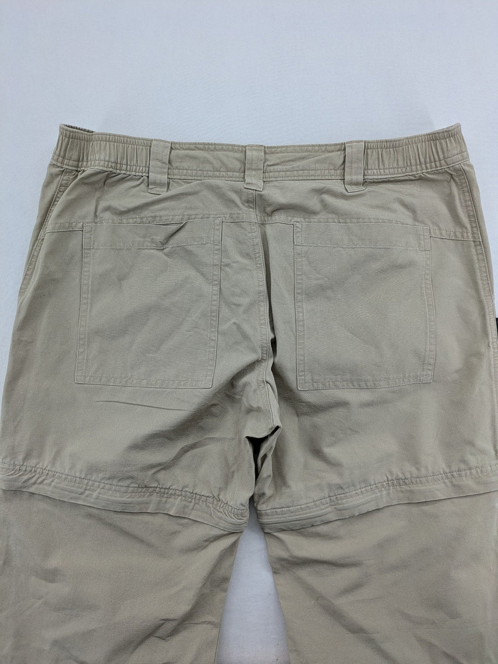 Quechua khaki convertible hiking pants with zip-off legs and durable cotton fabric.