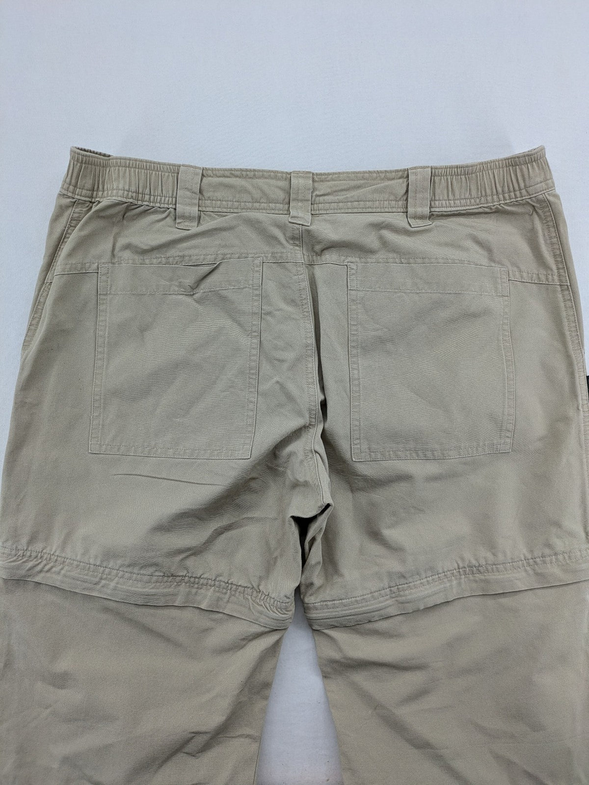Quechua khaki convertible hiking pants with zip-off legs and durable cotton fabric.