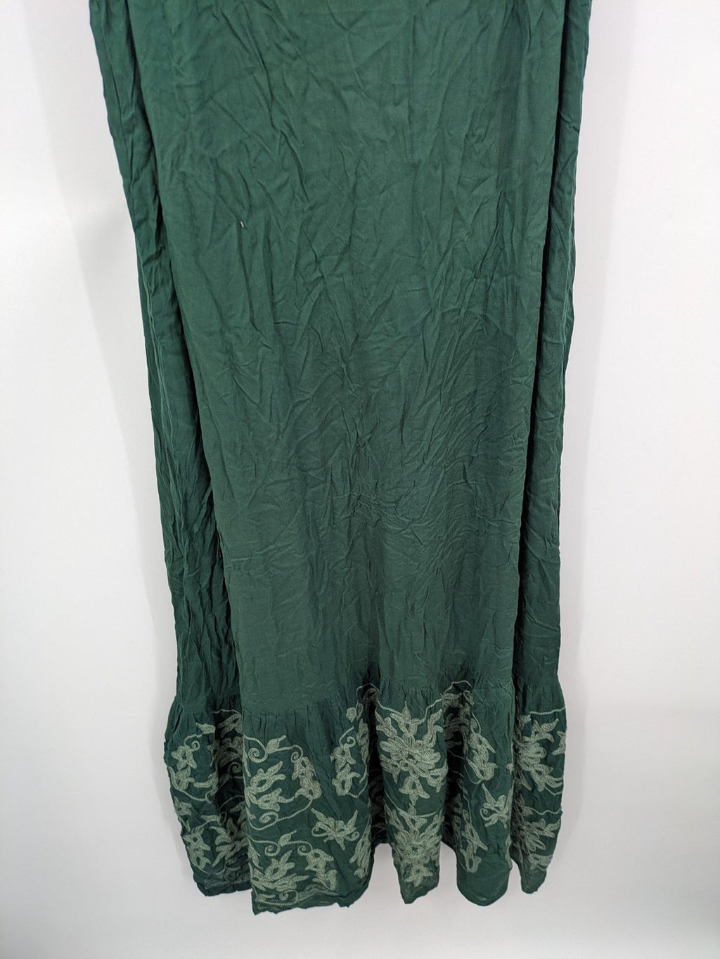 Boho green maxi dress with floral embroidery along tiered hem and adjustable spaghetti straps.