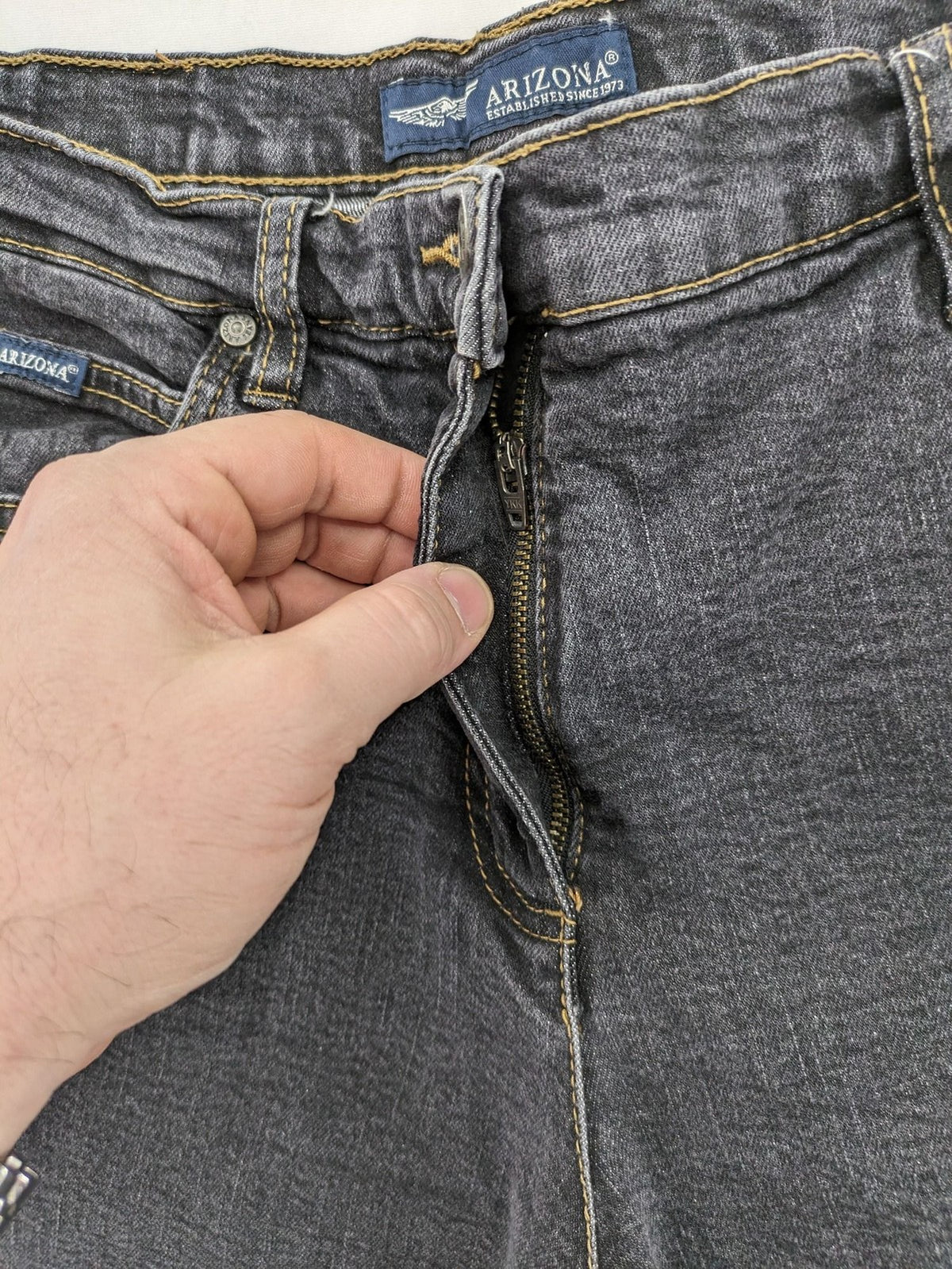 Bootcut grey low rise bootcut jeans five-pocket design with zipper and button closure.