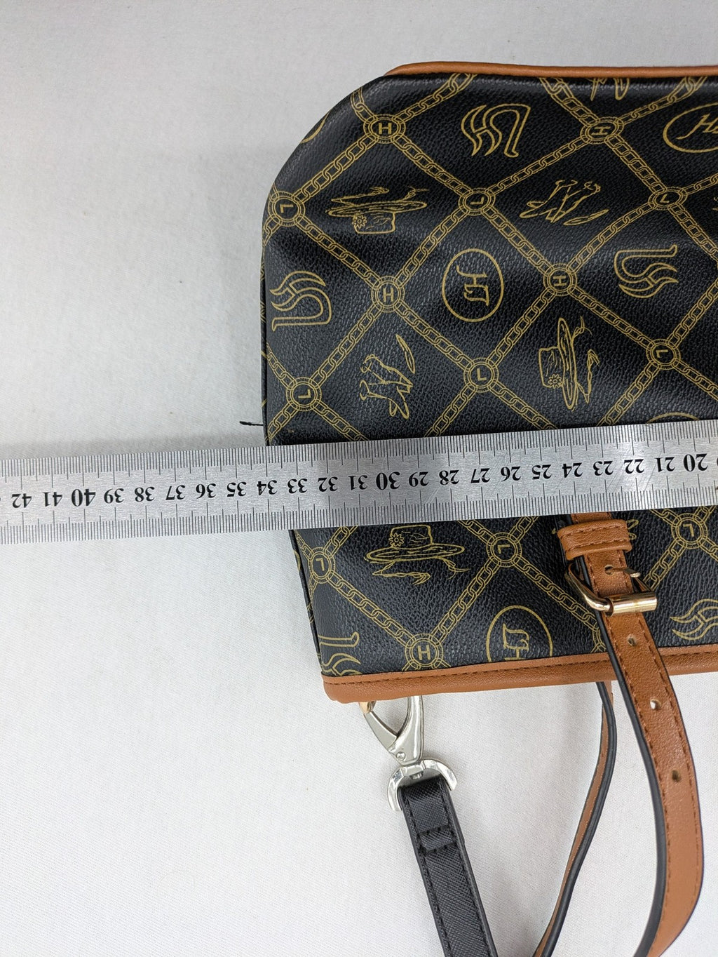 L&H brown and black handbag with monogram pattern and gold accents, versatile shoulder strap.
