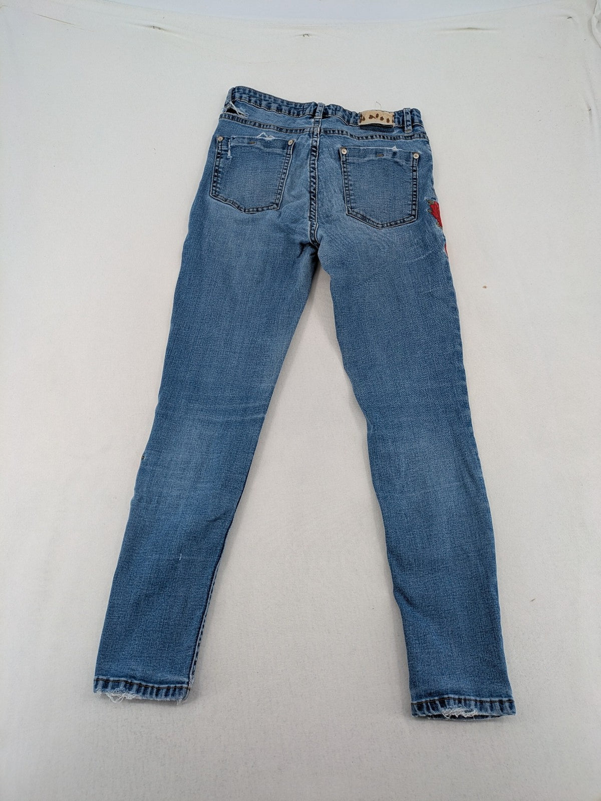 Jennyfer pink skinny jeans with distressed details and red rose embroidery on hips and knees.