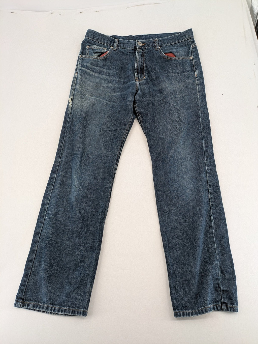 Indygo blue straight jeans 5-pocket style with subtle red pocket detail, cotton material.