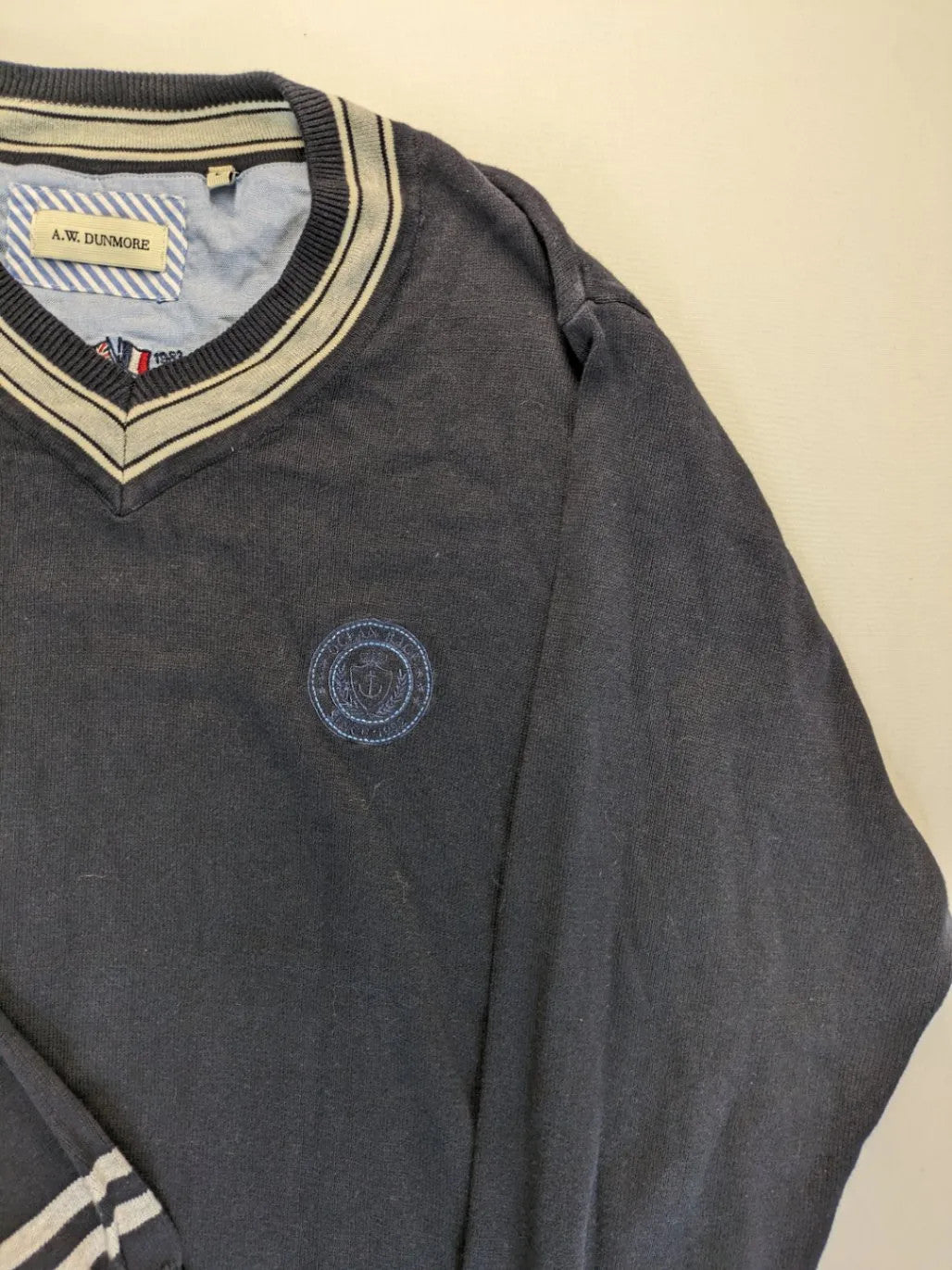 dunmore turtle neck jumper dark blue with striped trims and embroidered crest logo