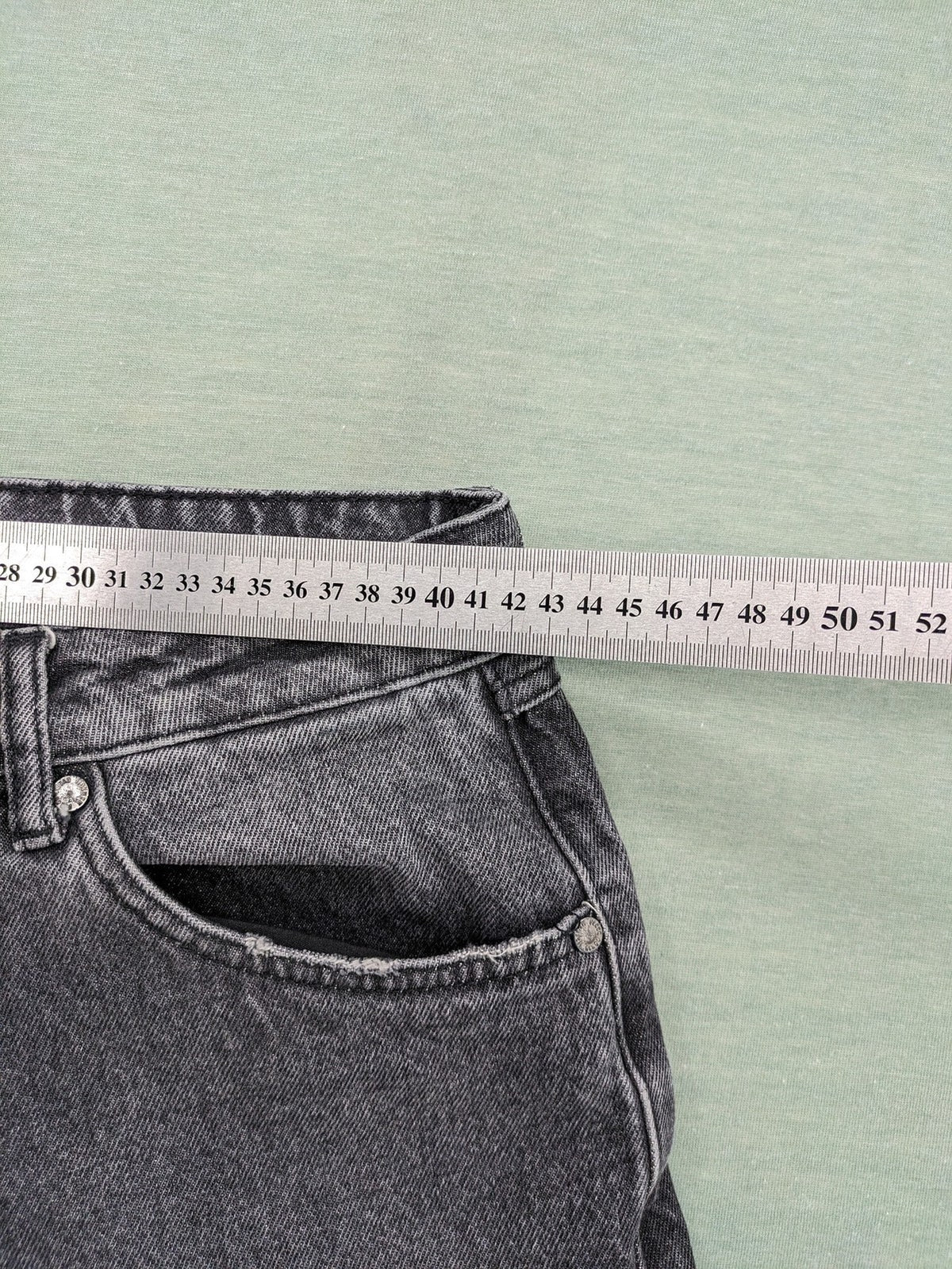 Black Squad black straight jeans with Gothic "Paranoid" lettering and faded finish.