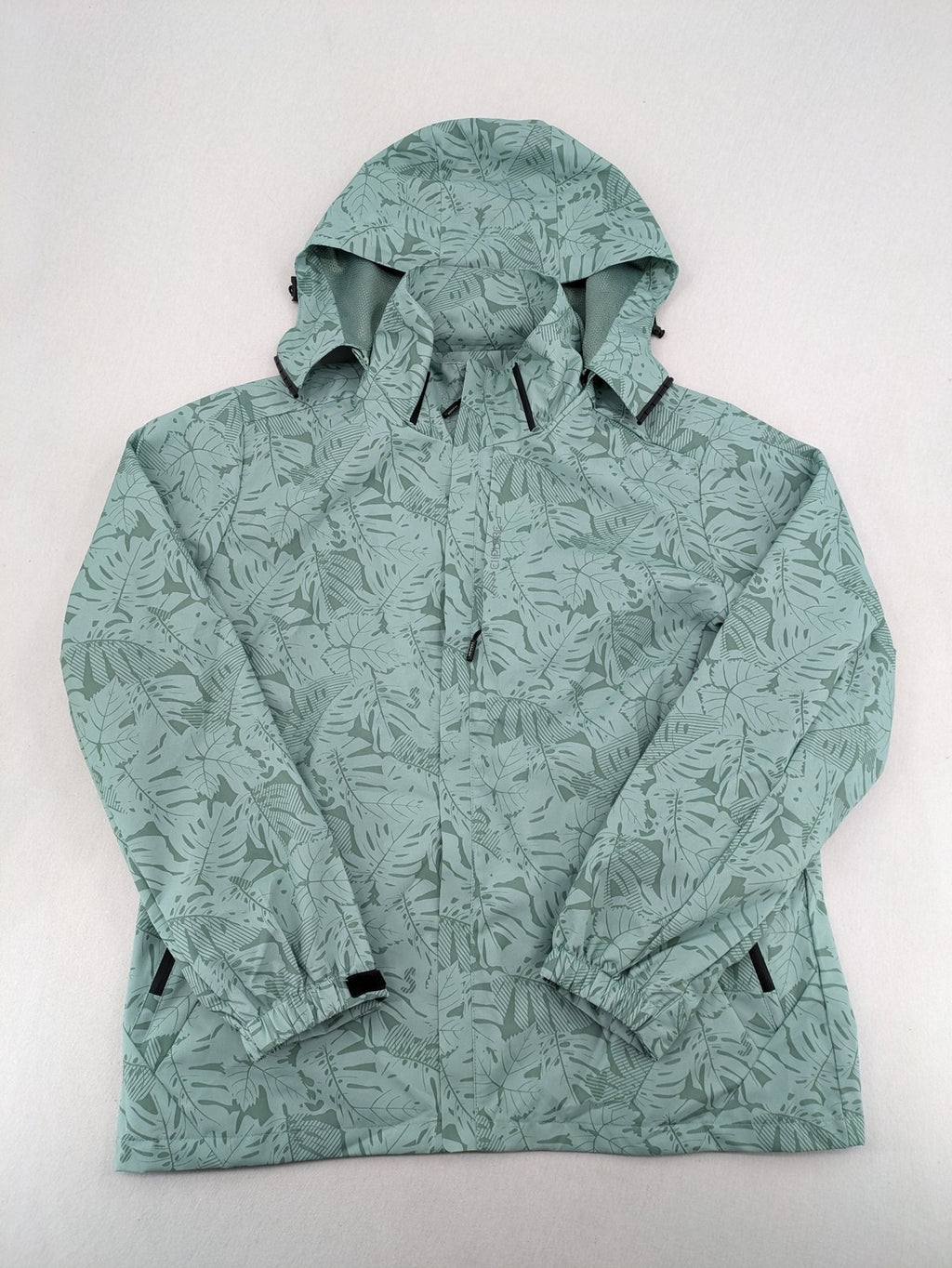 Outdoor green jacket with allover leaf print, adjustable hood, and front zipper.