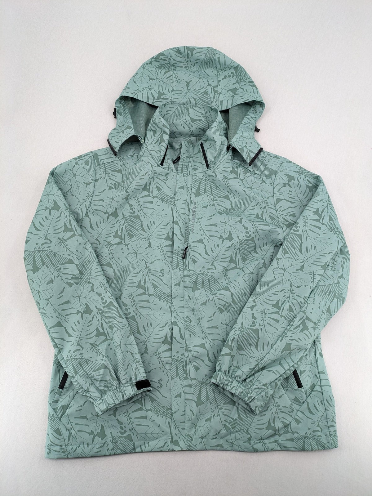 Outdoor green jacket with allover leaf print, adjustable hood, and front zipper.