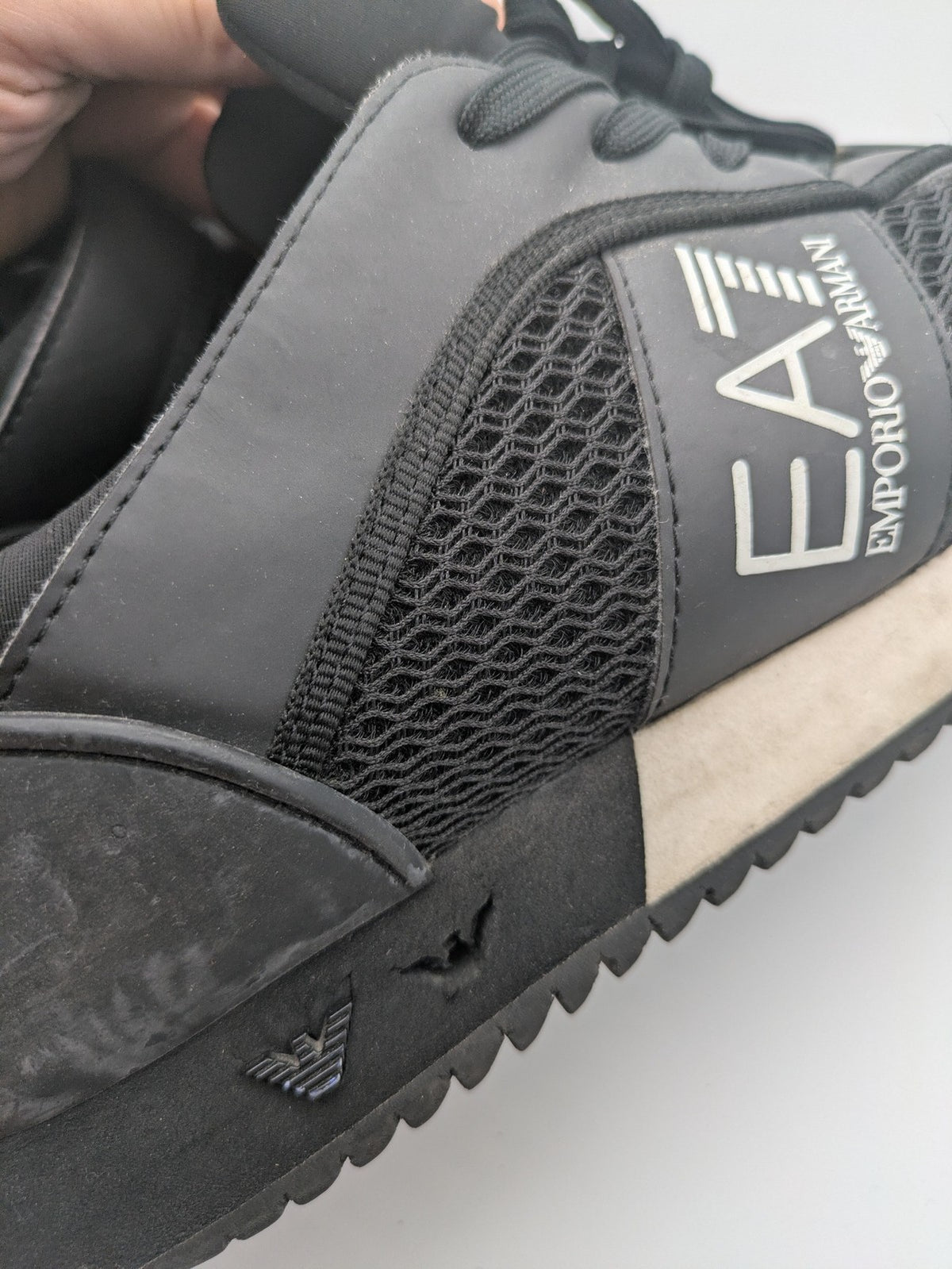 EA7 Emporio Armani beige and black sneakers with prominent EA7 branding and breathable mesh details.