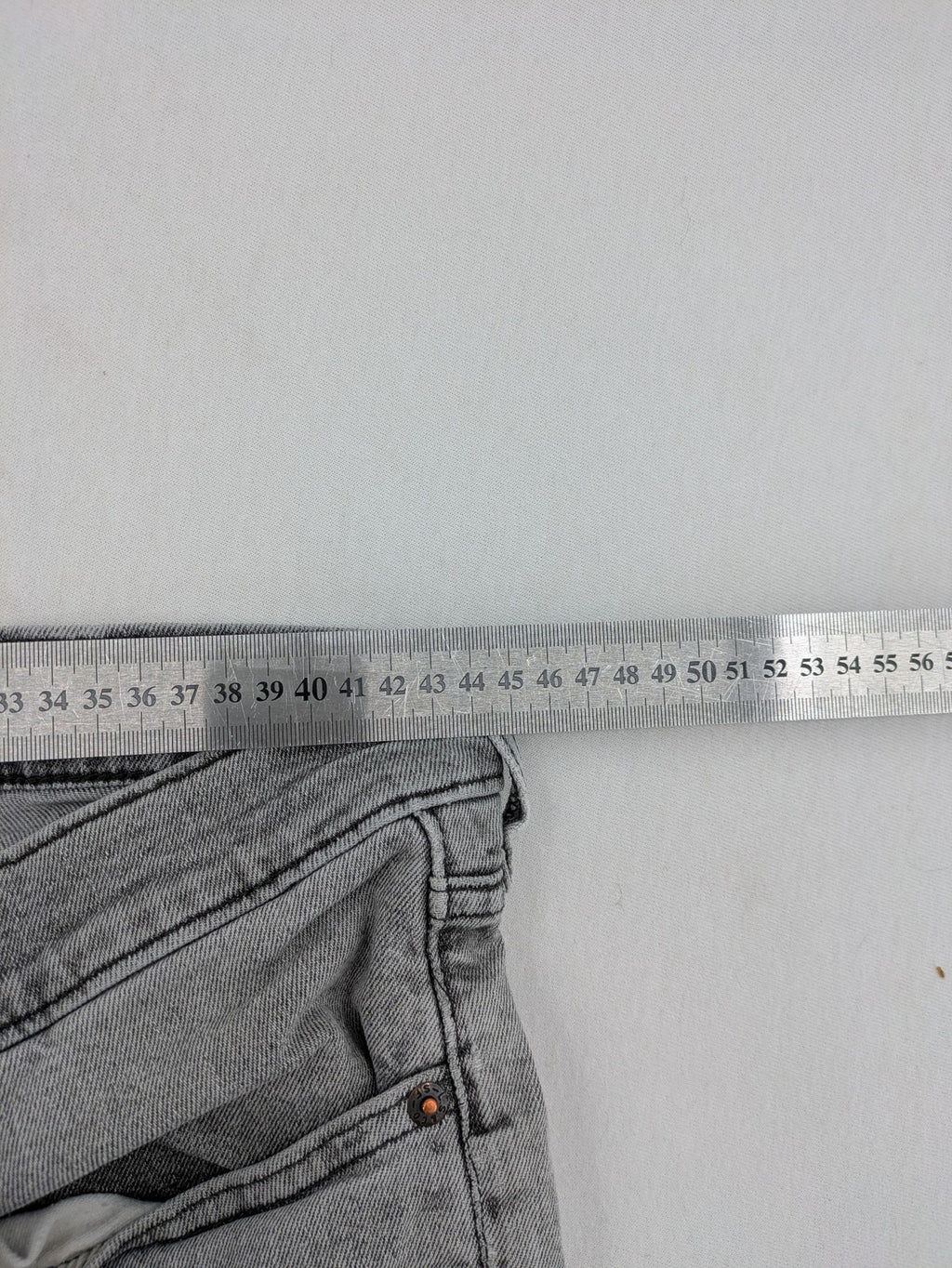 Levi's grey slim fit jeans with distressed knee details and classic logo patch.