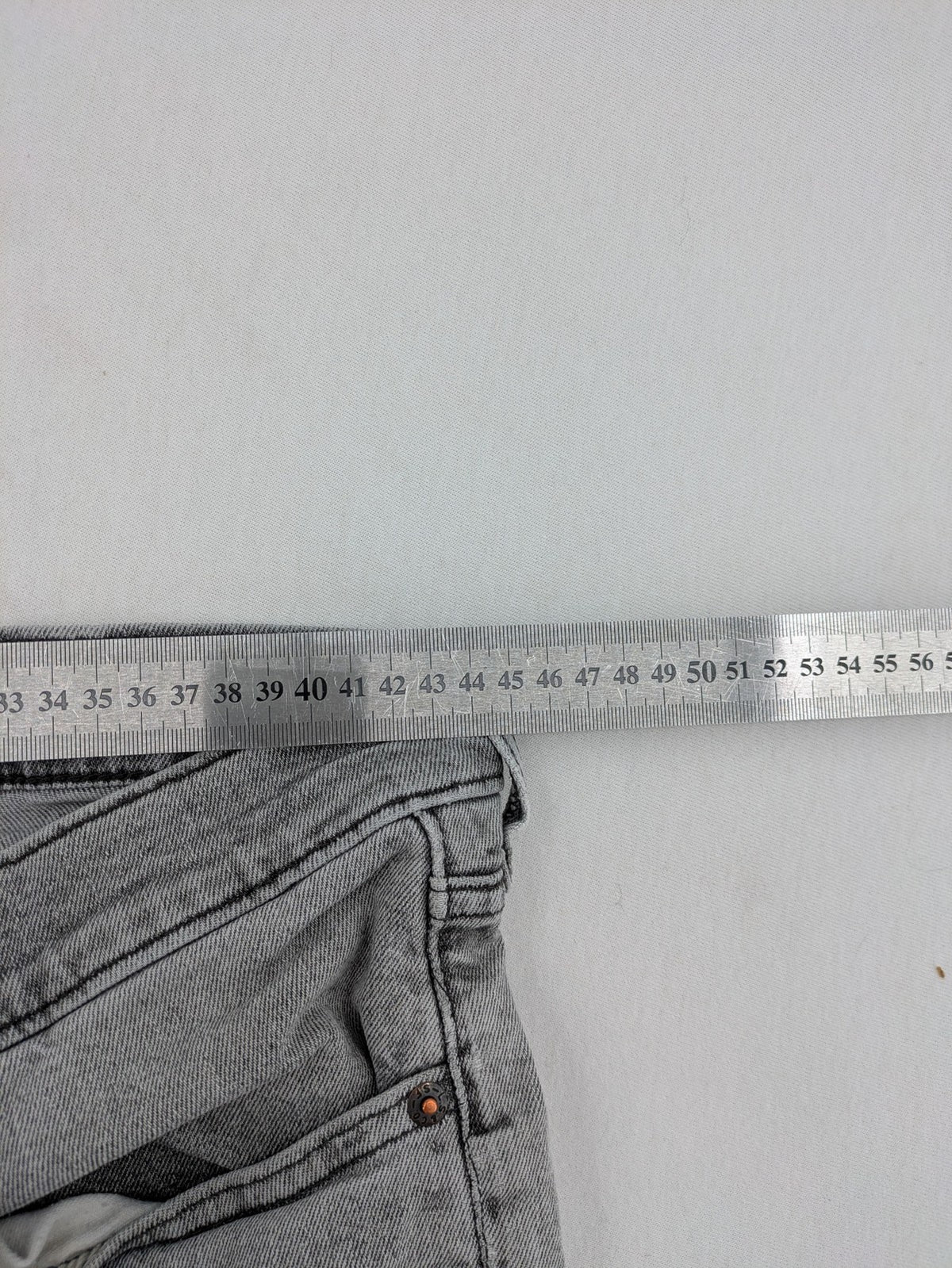 Levi's grey slim fit jeans with distressed knee details and classic logo patch.