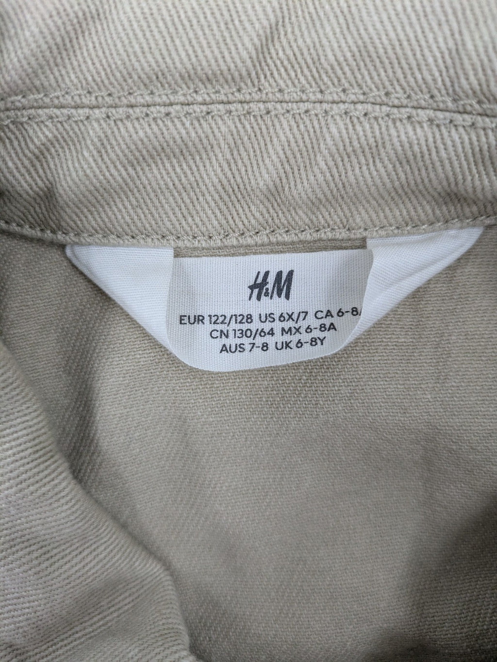 H&M beige twill coat with full zip, classic collar, and practical pockets.