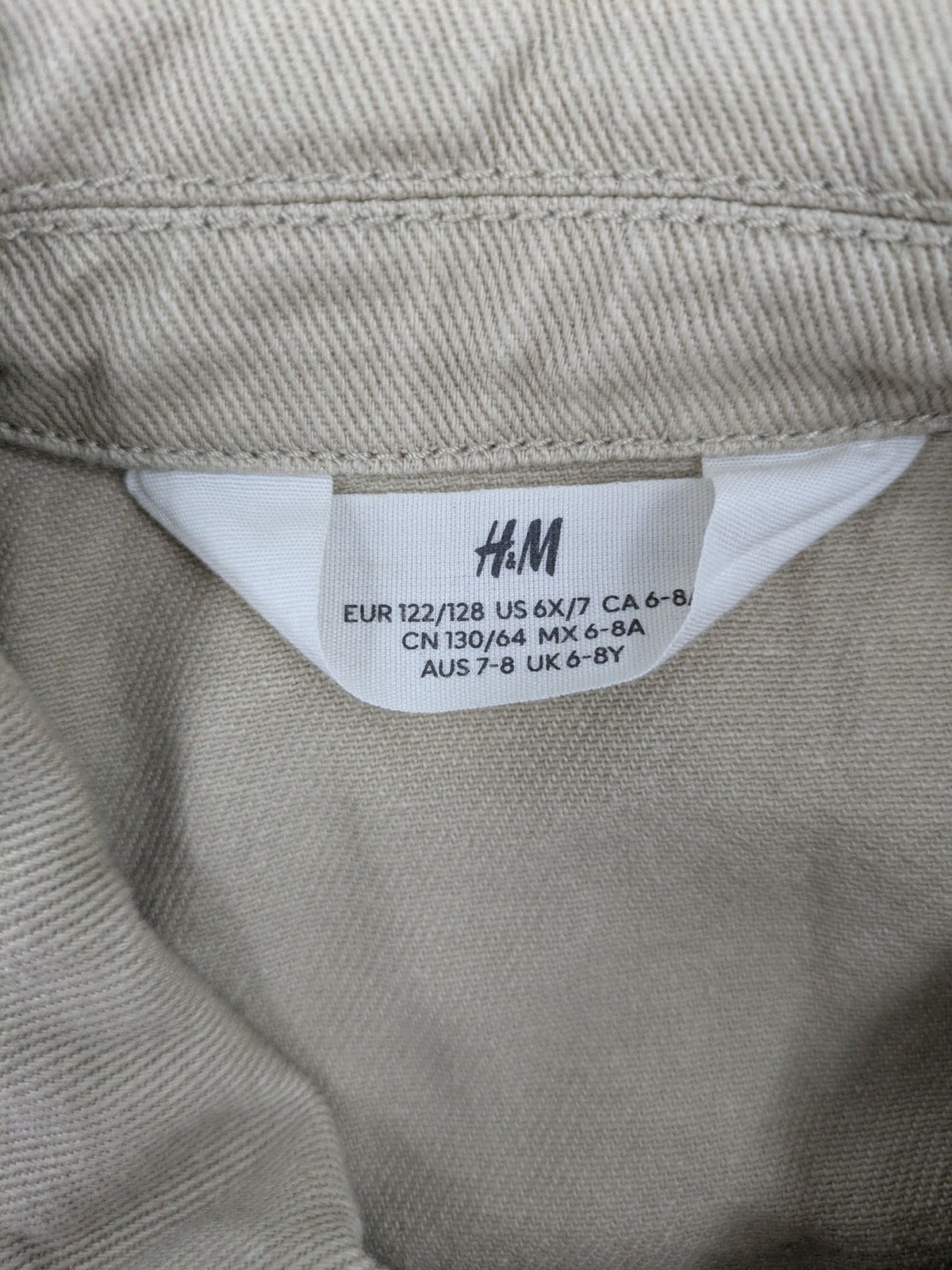 H&M beige twill coat with full zip, classic collar, and practical pockets.