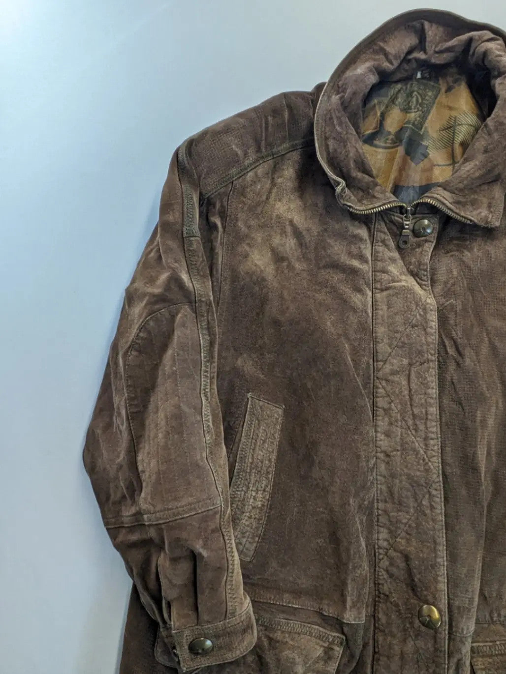 Vintage brown leather jacket with graphic lining, zip closure, and button placket.