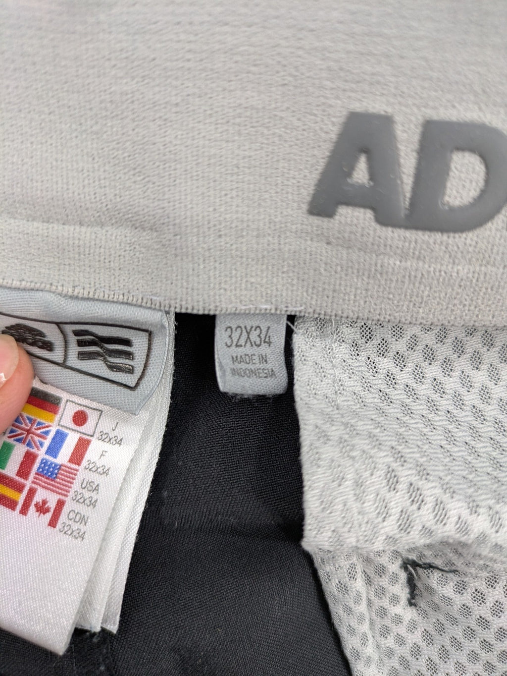 Adidas grey pants with 3-stripe logo, flat-front design, made from performance material.