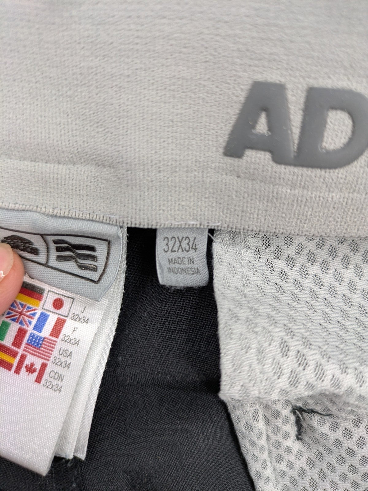 Adidas grey pants with 3-stripe logo, flat-front design, made from performance material.