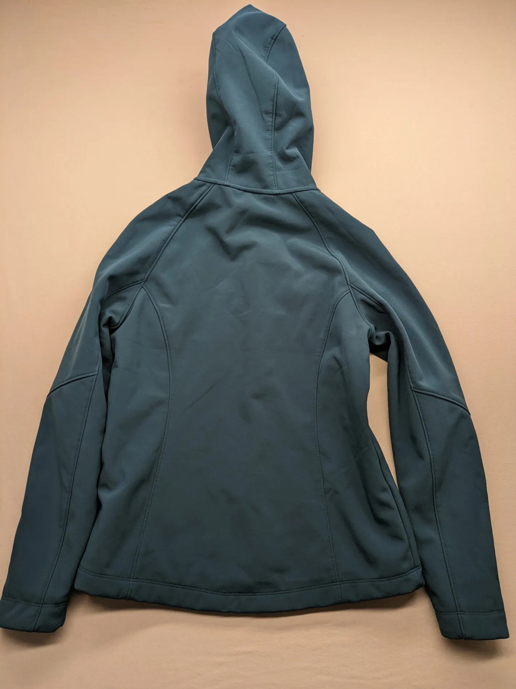 Kirkland Signature blue softshell jacket with hood, fleece lining, and zippered pockets.