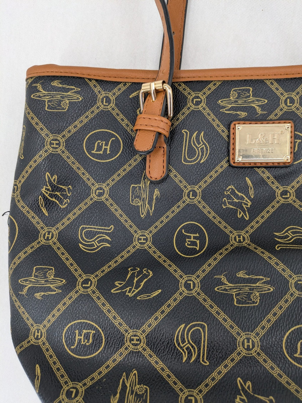L&H brown and black handbag with monogram pattern and gold accents, versatile shoulder strap.