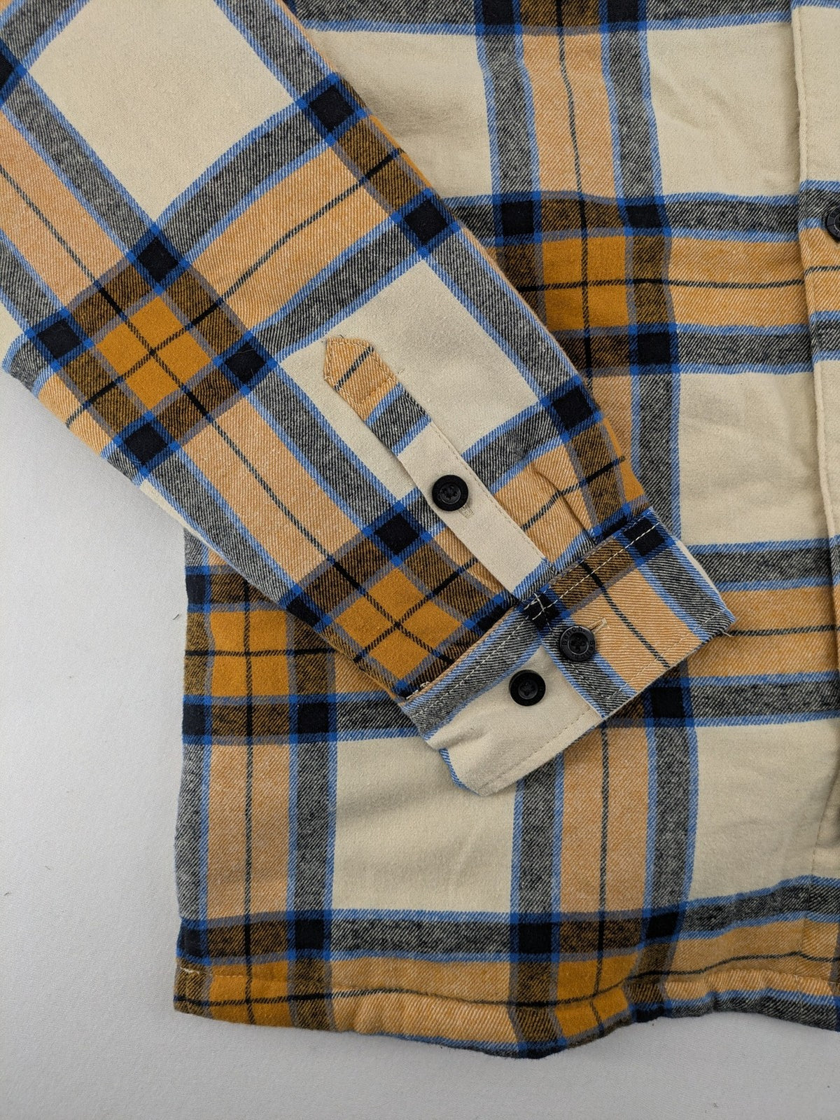 Bench cream flannel jacket with check pattern, black hood, and button placket.