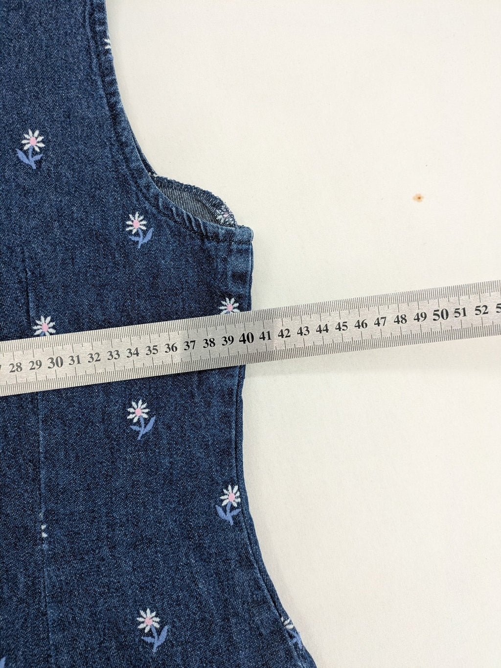 Damen blue denim mini dress with all-over white and light blue floral embroidery.