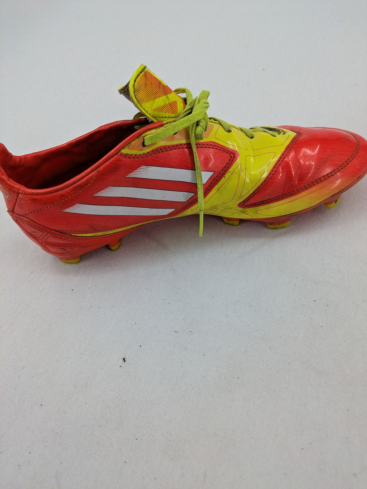 Adidas F50 soccer shoes red and yellow with three-stripe logo and lightweight synthetic material.