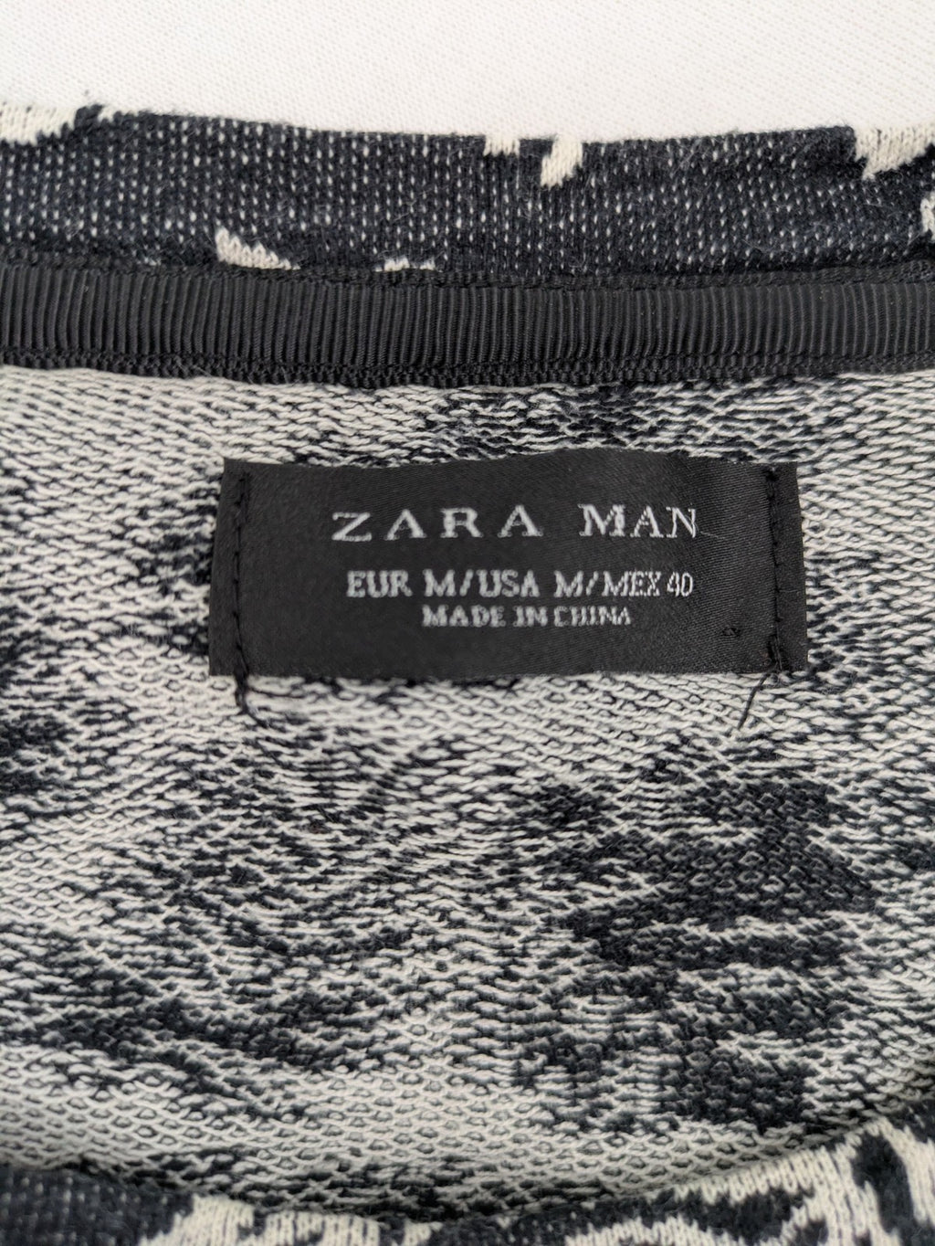 Zara Man black and white t-shirt with allover leaf print and textured knit fabric.