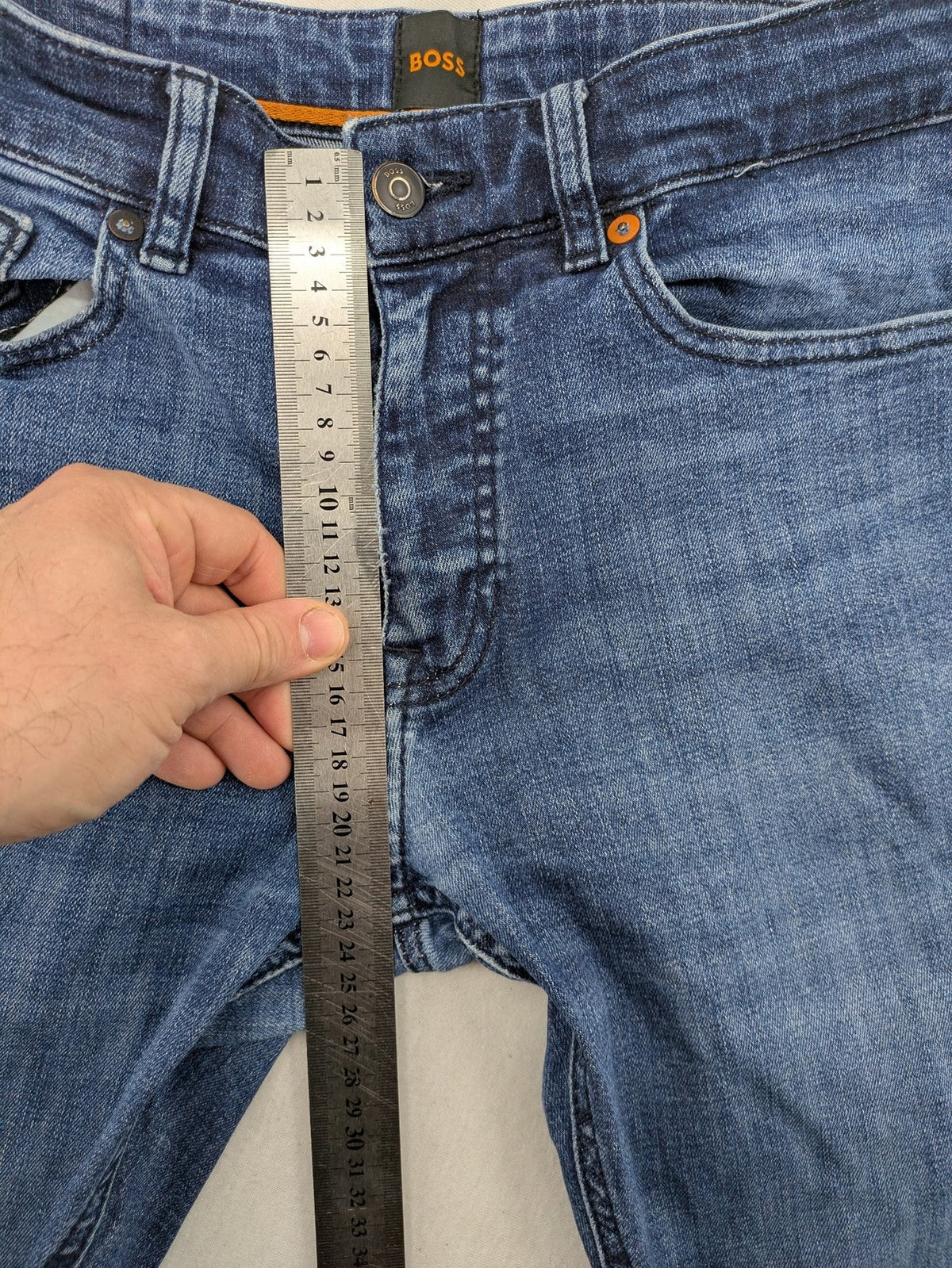 BOSS blue slim fit jeans with logo, five-pocket design, and button fly.