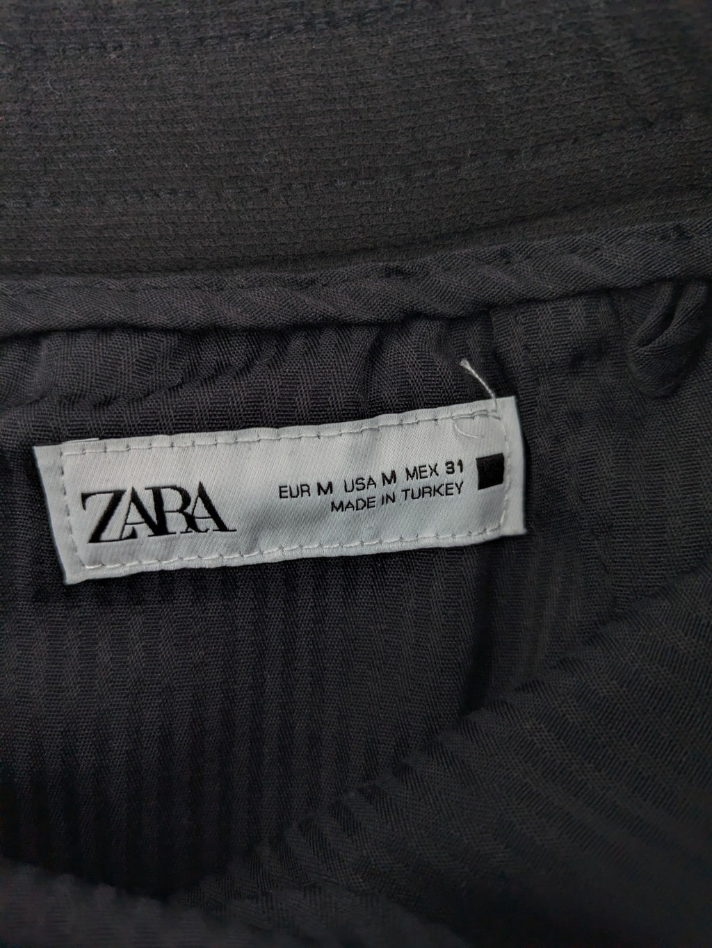 Zara black shorts with elastic drawstring, pleats, and rolled hem detail.