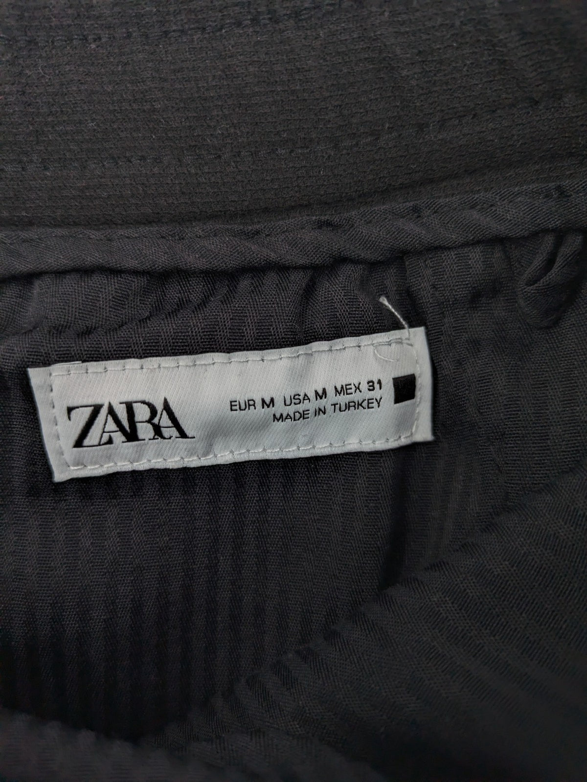 Zara black shorts with elastic drawstring, pleats, and rolled hem detail.