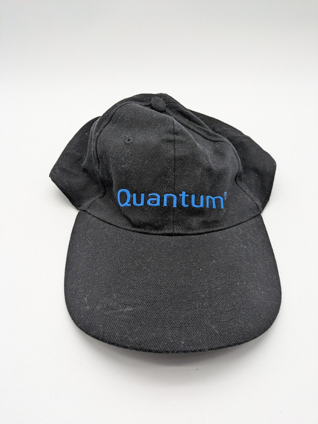 Quantum black snapback cap with bright blue embroidered logo and adjustable snapback closure.