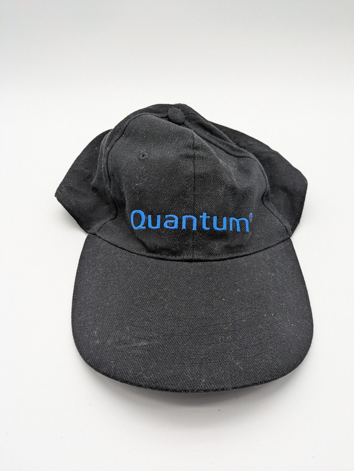 Quantum black snapback cap with bright blue embroidered logo and adjustable snapback closure.
