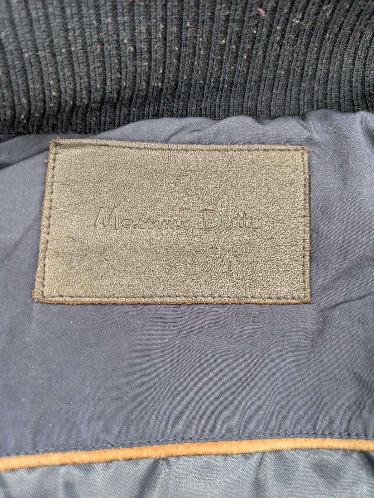 Massimo Dutti black quilted jacket with contrasting brown trim and ribbed side inserts.
