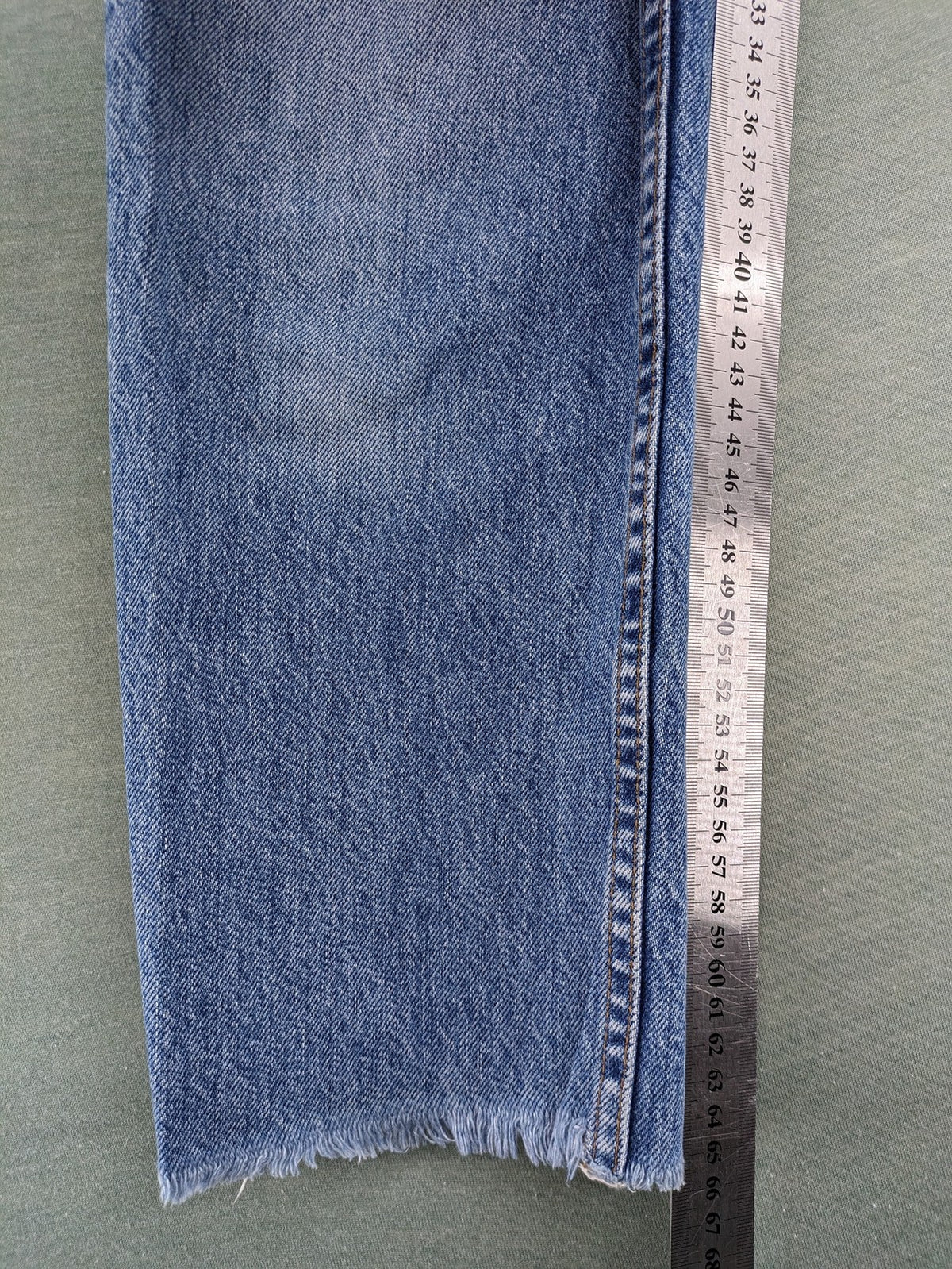 Re/Done blue straight jeans high rise with button fly and raw hem detail.