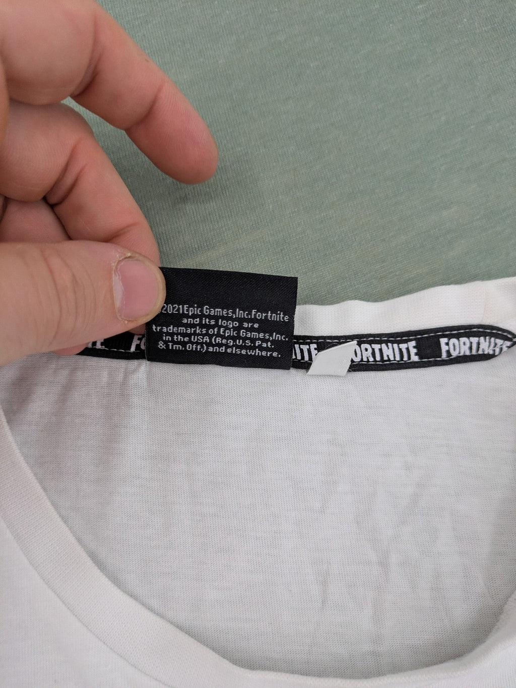 Fortnite white t-shirt with black chest stripe and Epic Games logo, 100% cotton.