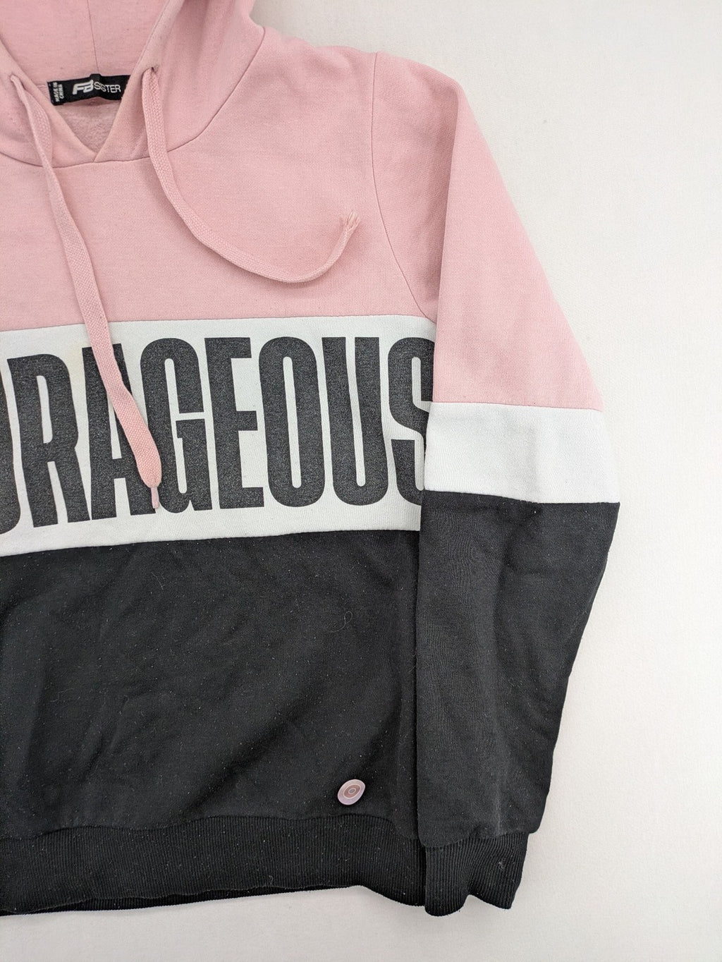 FB Sister multi hoodie colorblock design pink, white, black with "COURAGEOUS" graphic print.