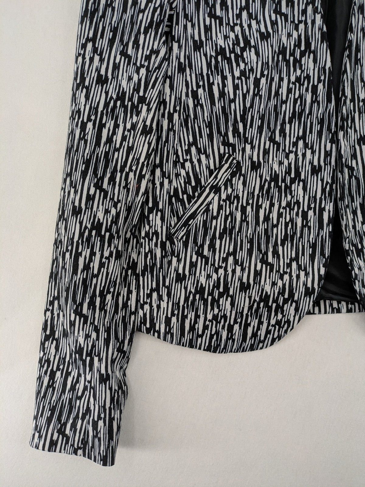 H&M Divided black and white patterned blazer with open front and two front pockets.
