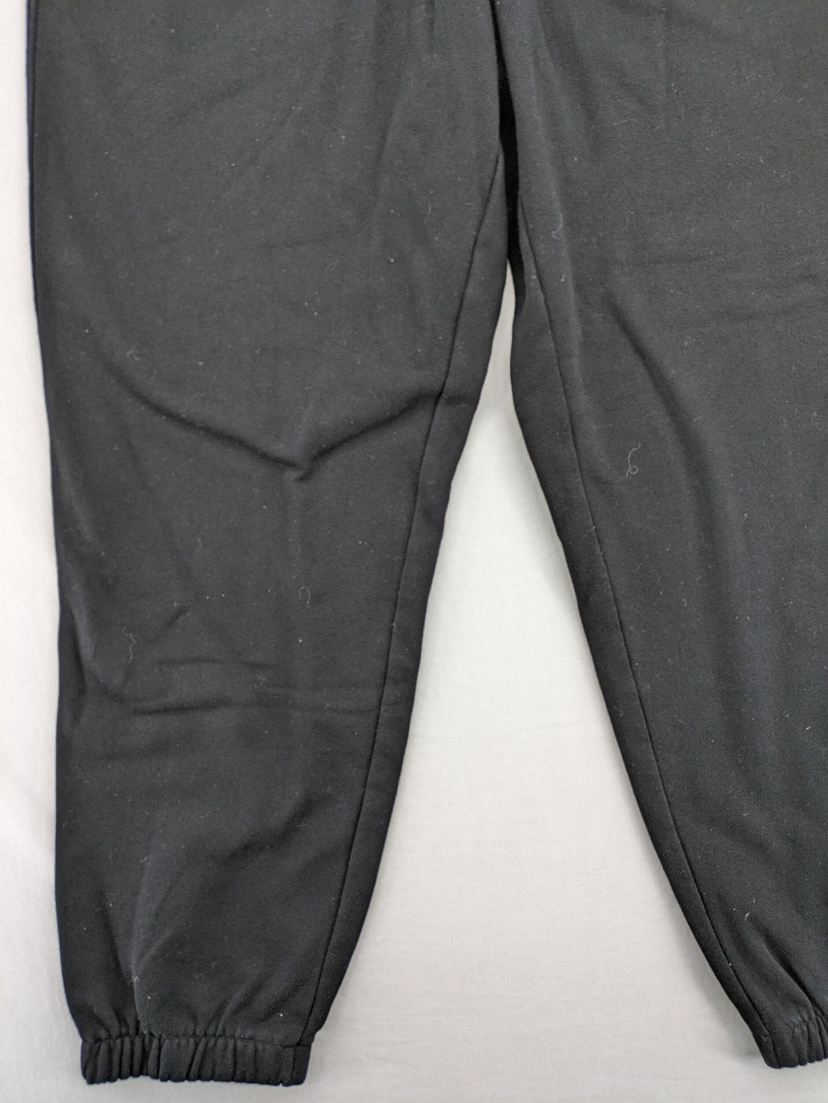 H&M black sweatpants with adjustable drawstring, elastic cuffs, and side pockets.