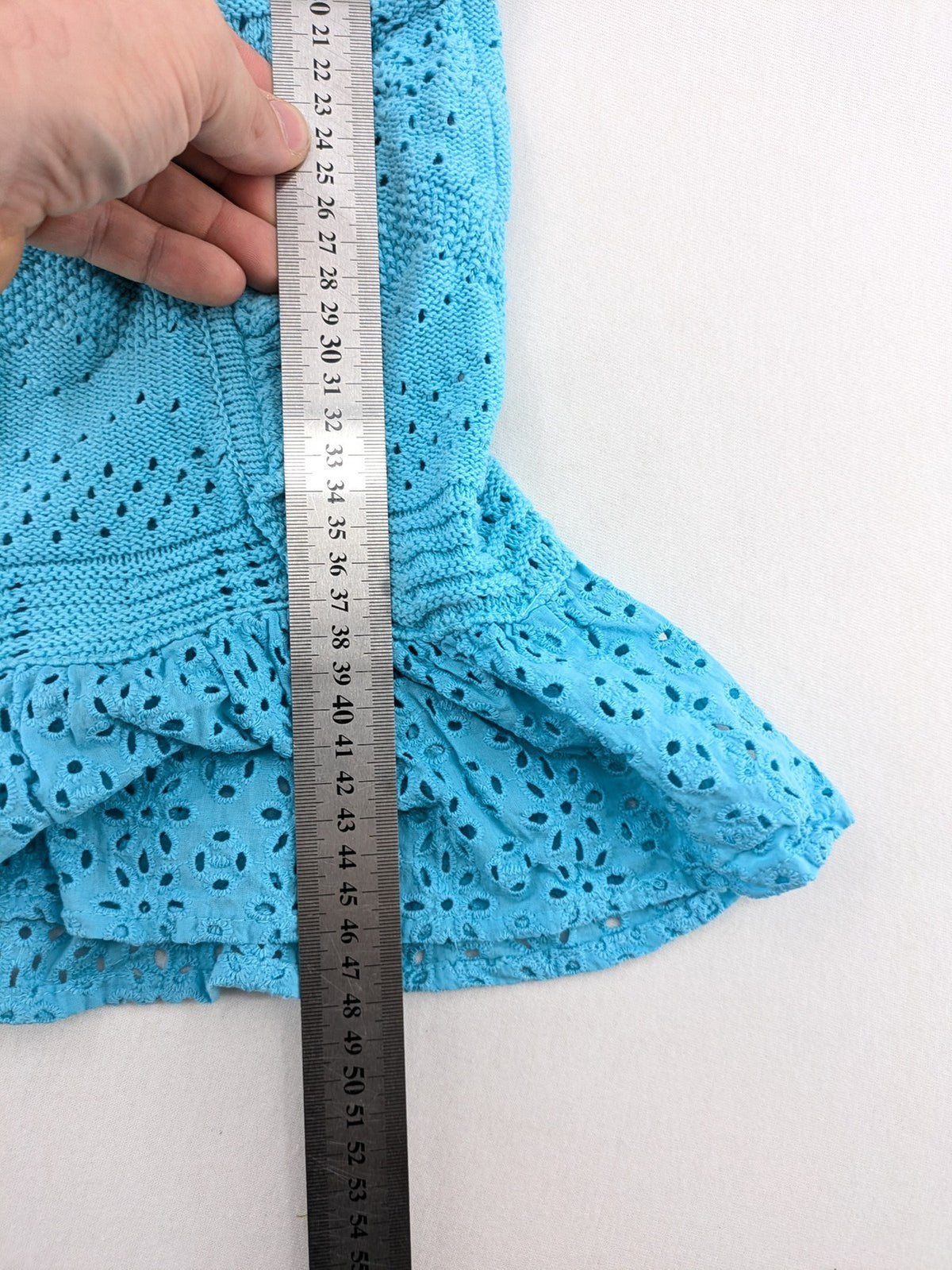 Springfield blue knit top with ruffled straps, peplum hem, and lace embroidery.