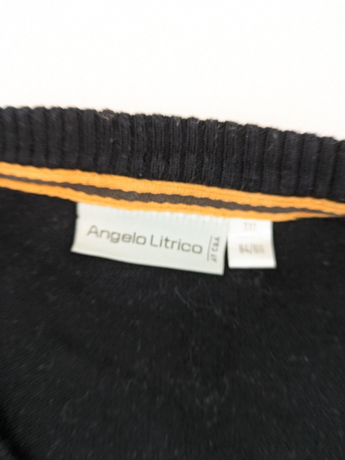 Angelo Litrico black knit jumper V-neck with tonal emblem and "Supreme Oil Quality" graphic.