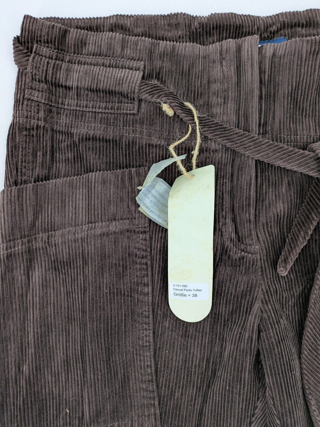 Alma & Lovis cream cord pants high-waist with matching belt and front pockets.
