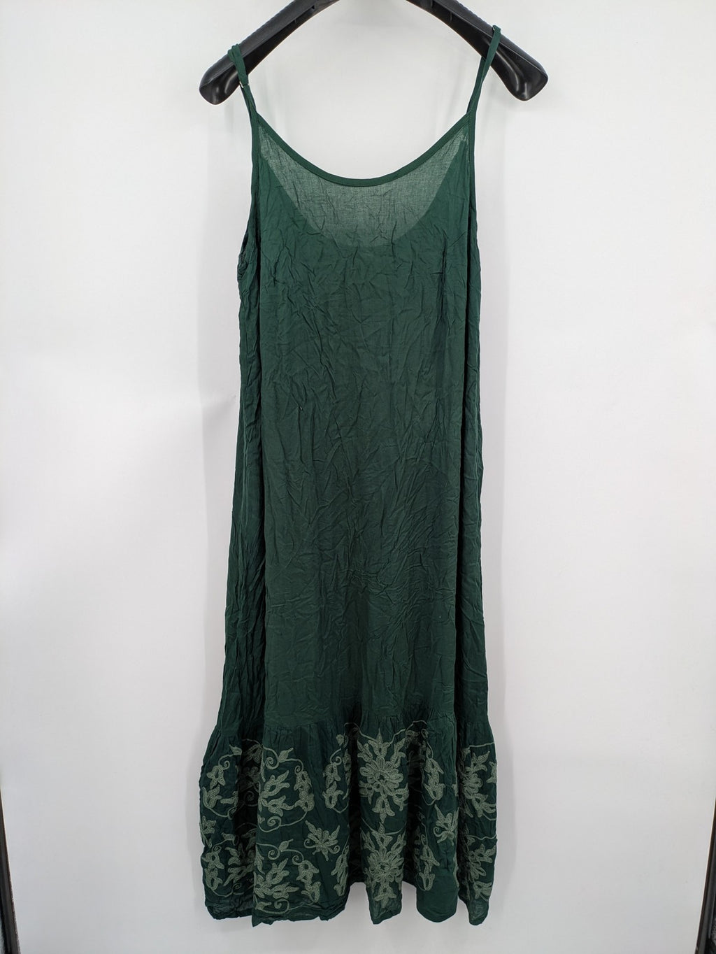 Boho green maxi dress with floral embroidery along tiered hem and adjustable spaghetti straps.