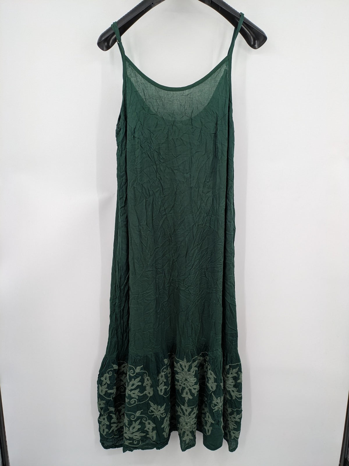 Boho green maxi dress with floral embroidery along tiered hem and adjustable spaghetti straps.