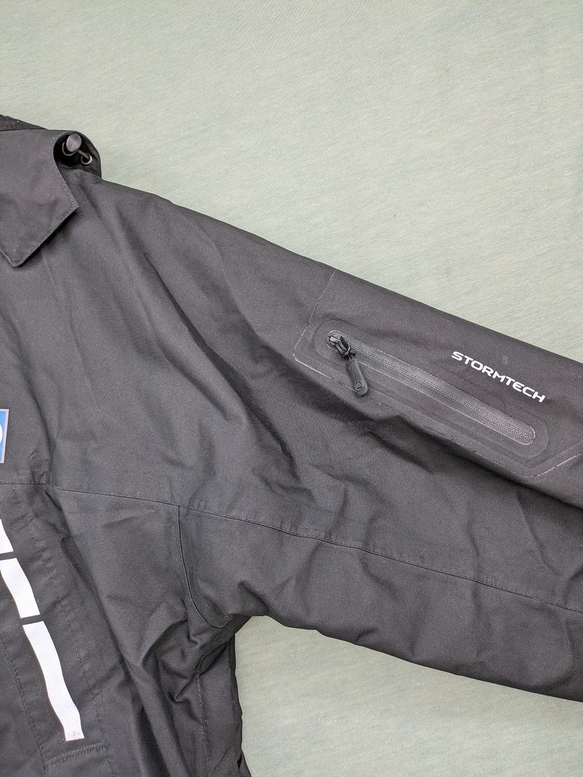 Stormtech black waterproof jacket with ZF logo, H2Xtreme technology, front zipper, and hood.