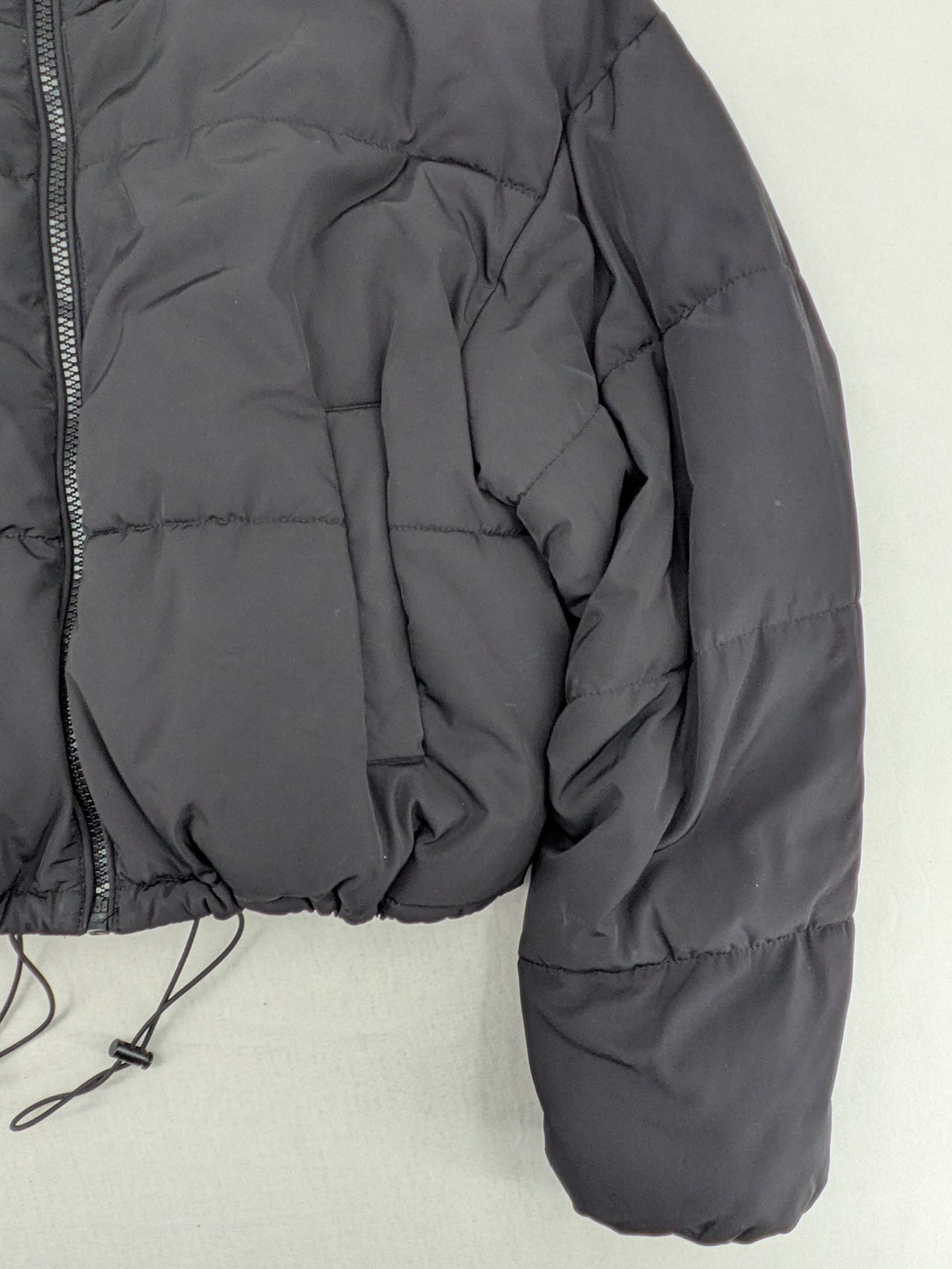 H&M Divided black cropped puffer jacket with zip closure and high collar.