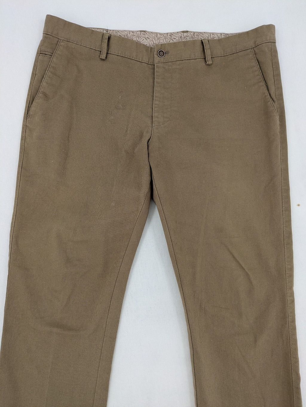 Süvari khaki chino pants flat-front design with patterned waistband detail, cotton blend material.