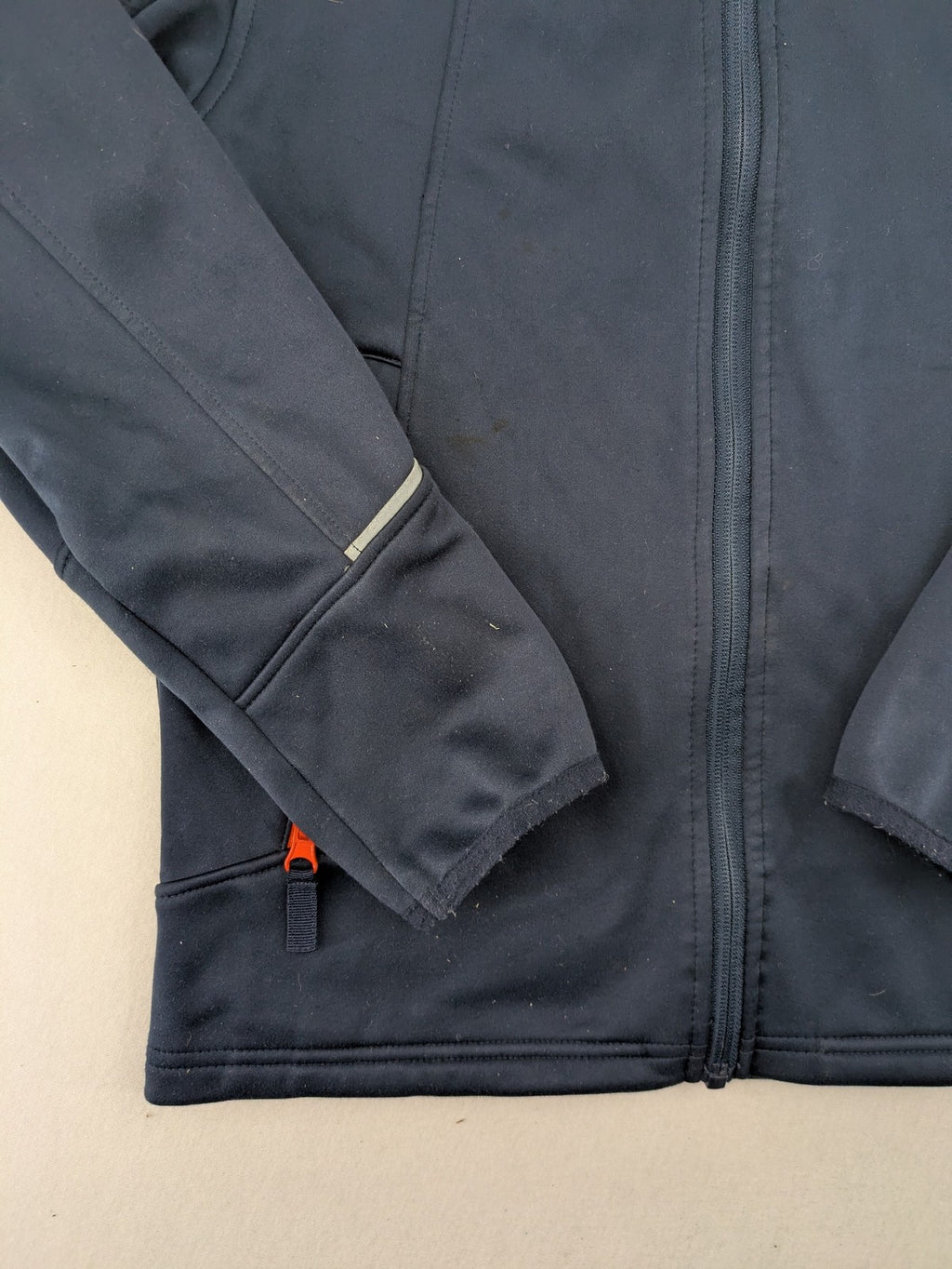 Crane navy softshell jacket with fleece lining, full zip, orange accent zippers.