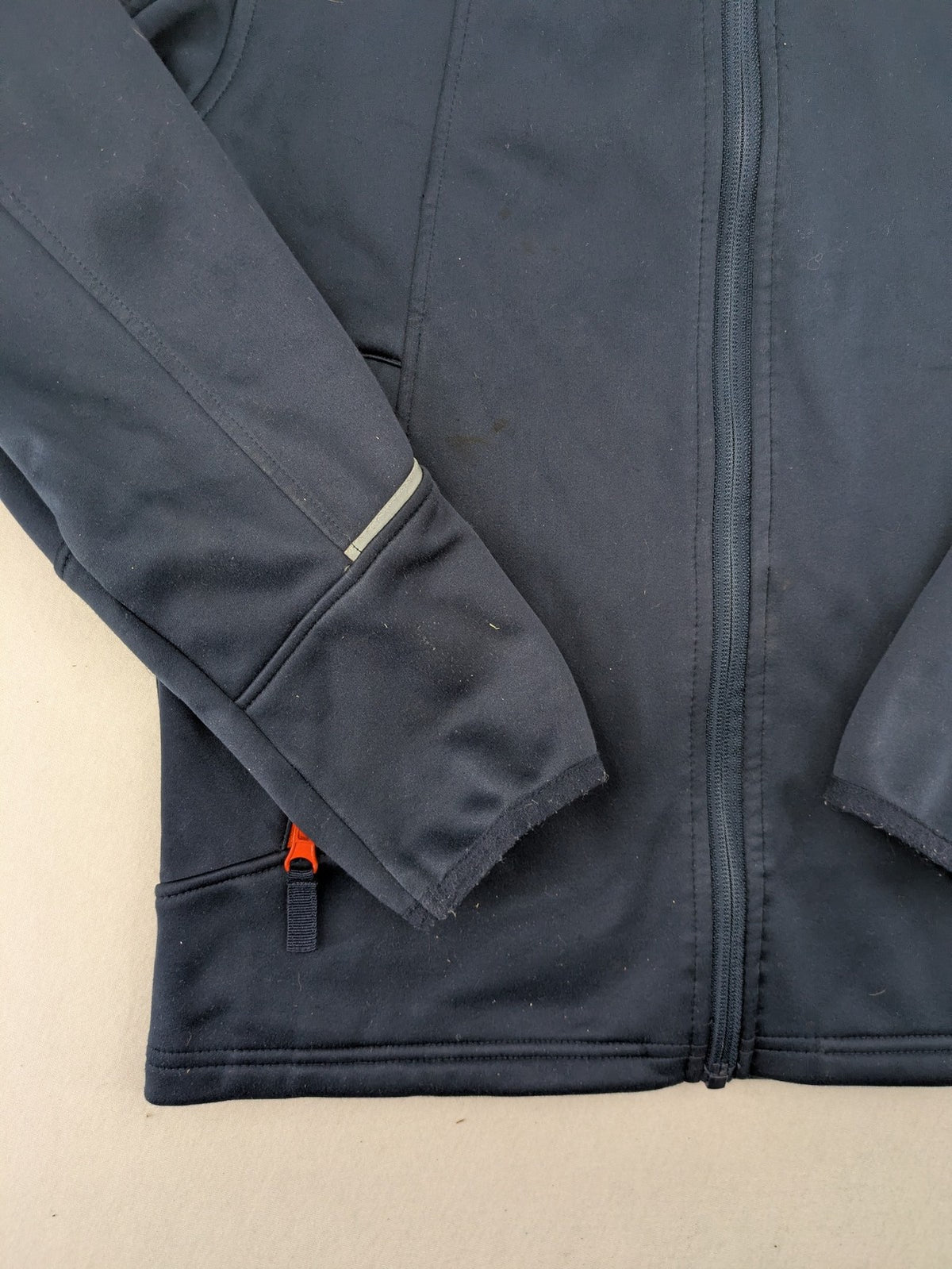 Crane navy softshell jacket with fleece lining, full zip, orange accent zippers.