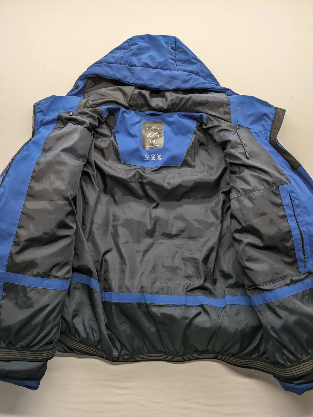 C&A blue winter jacket with hood, zip closure, and multiple pockets, used condition.