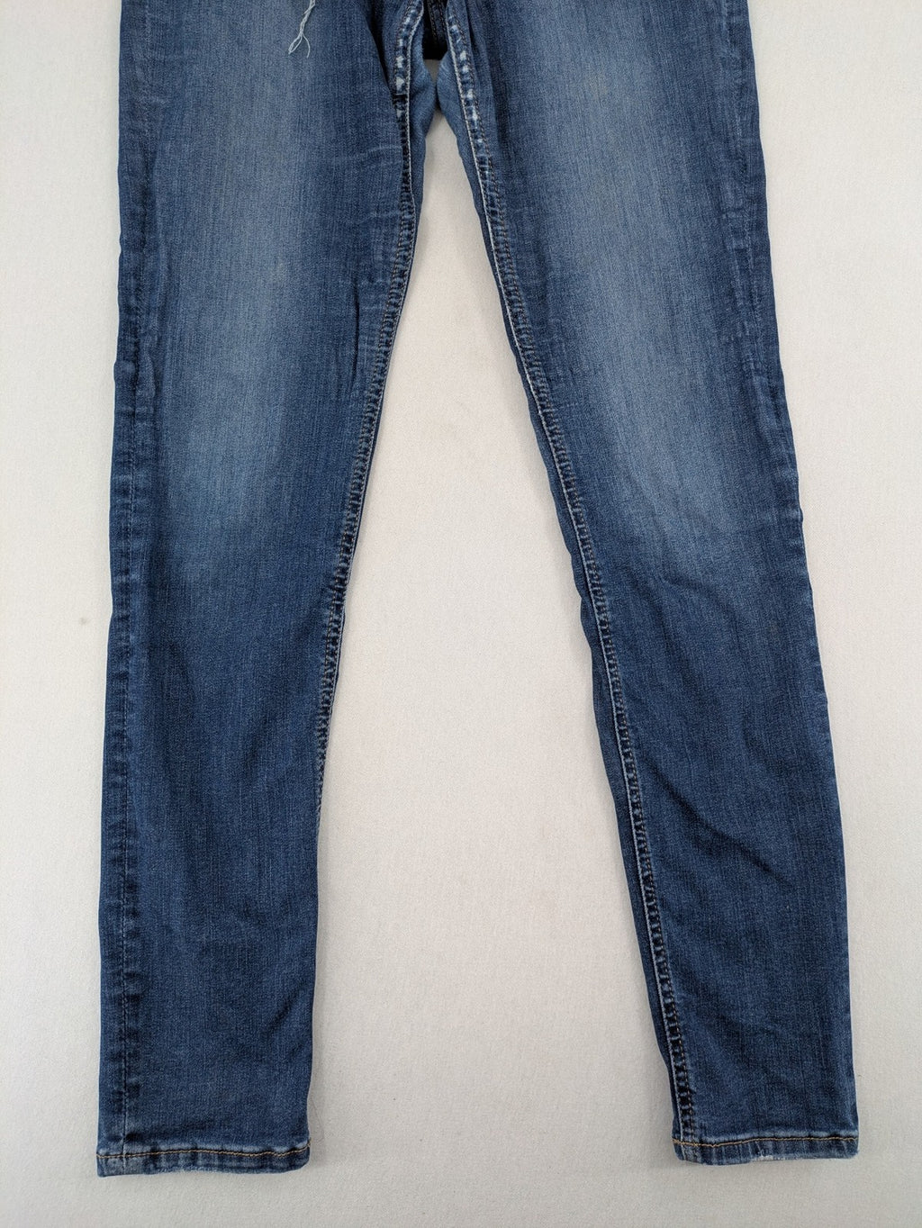 H&M blue skinny jeans with distressed details and comfortable stretch denim material.