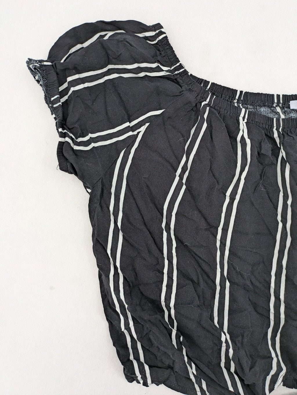 Hailys black and white striped crop top with front tie and off-shoulder design.