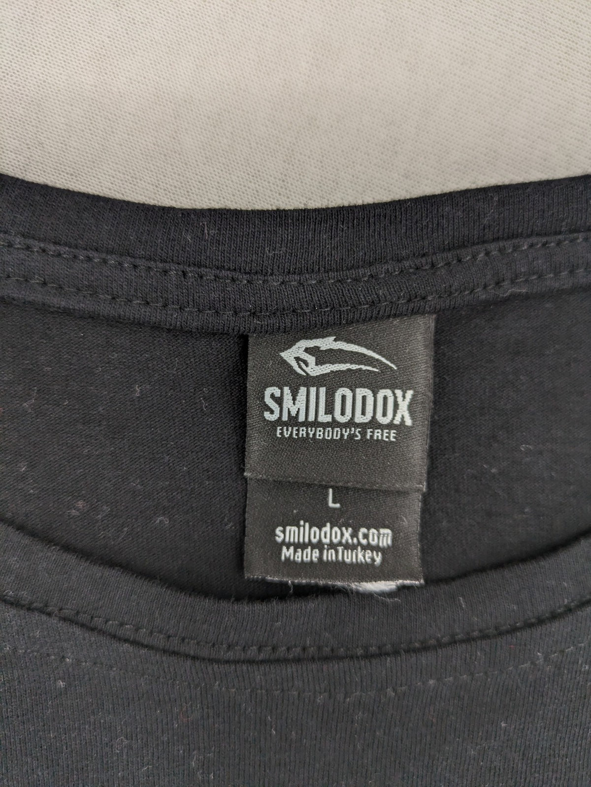 Smilodox black T-shirt minimalist design with subtle brand patch, 100% cotton.